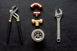 “Technician fitting kitchen tap in Berrylands family home”